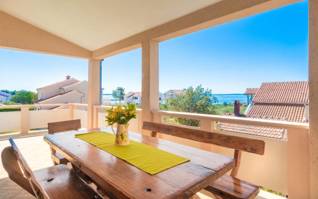 un tavolo di legno su un balcone con vista sull'oceano di Apartment Tomislav a Vir (Puntadura)