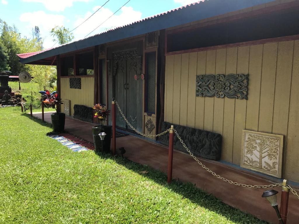 una casa con un porche con una cadena alrededor en Hawaiian Balinese Temple House en Pahoa