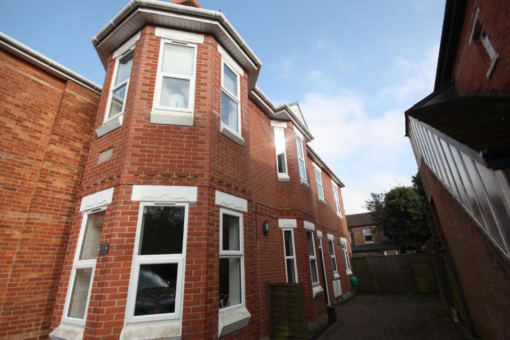 a red brick building with white windows on a street at Holiday Home Hot Tub & Sauna in Bournemouth