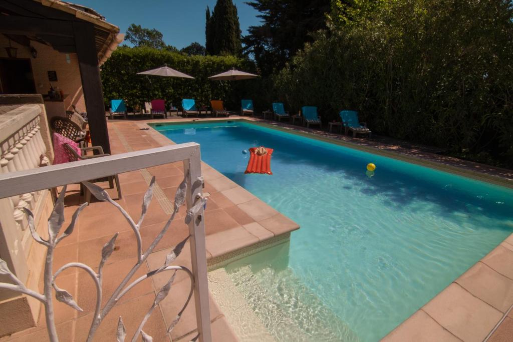 - une piscine avec des chaises et un ballon à l'eau dans l'établissement Villa Carpe Diem, à La Roquette-sur-Siagne