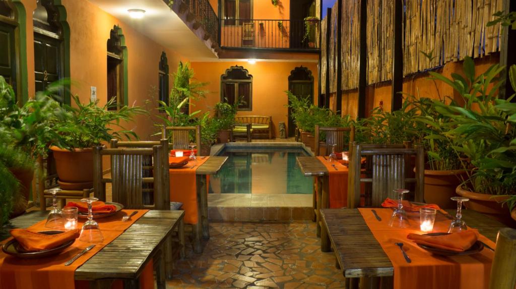 a restaurant with a swimming pool and tables and chairs at Boutique Hotel Maharaja in Granada