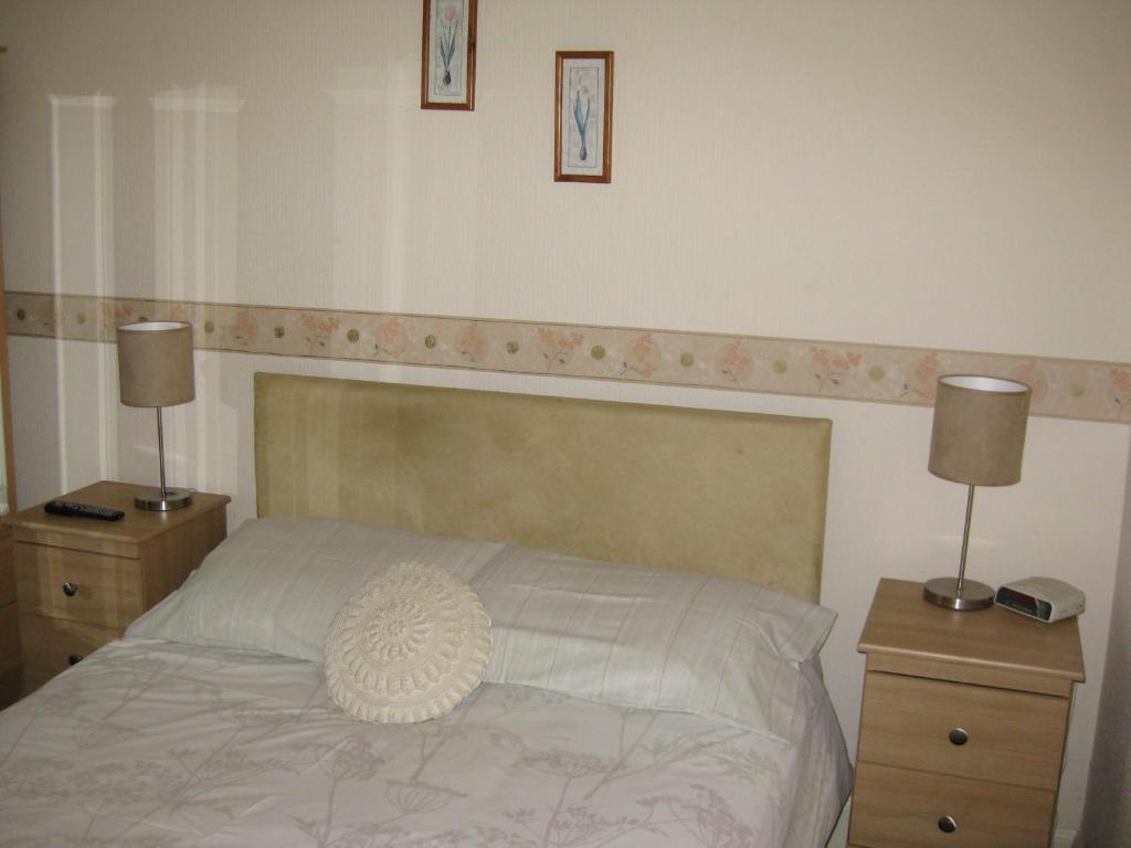 a bedroom with a bed and a lamp at Kilkerran Guest House in Ayr