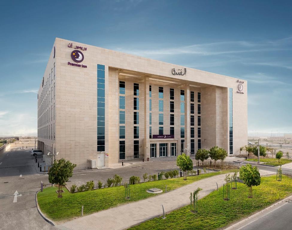 un edificio con un reloj al costado. en Premier Inn Doha Education City en Doha