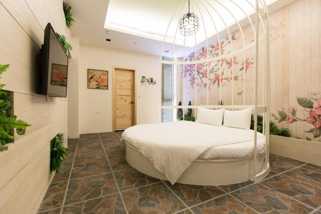 a bedroom with a white bed with a flower mural at Bookline B&amp;B in Hualien City