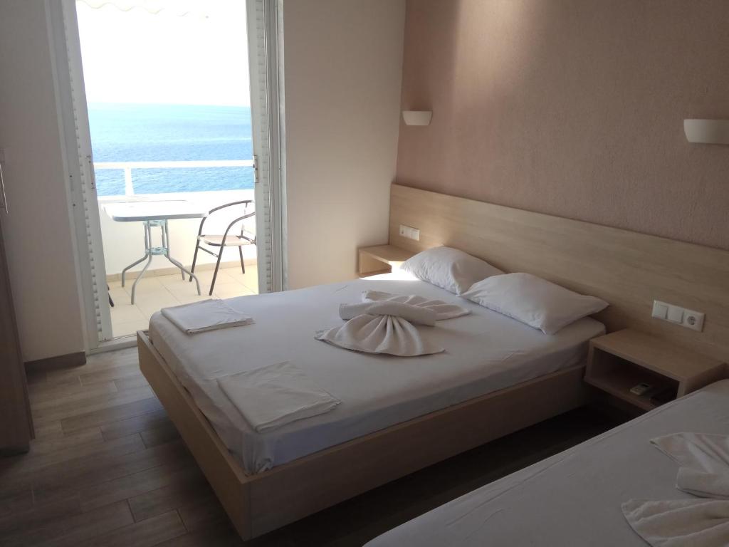 a bedroom with a bed with a view of the ocean at Karantola Studios Kallirachi in Skala Kallirachis