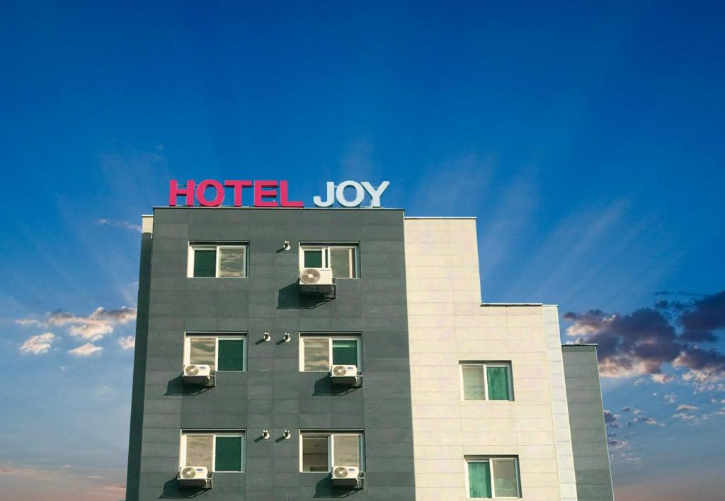 un edificio con un signo de alegría de hotel encima en Hotel Joy near Camp Humphres, en Pyeongtaek