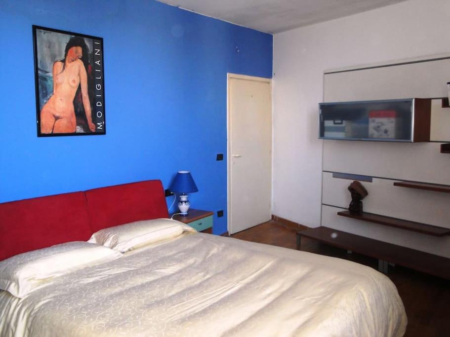 a bedroom with a large bed and a blue wall at cozy private room in Florence