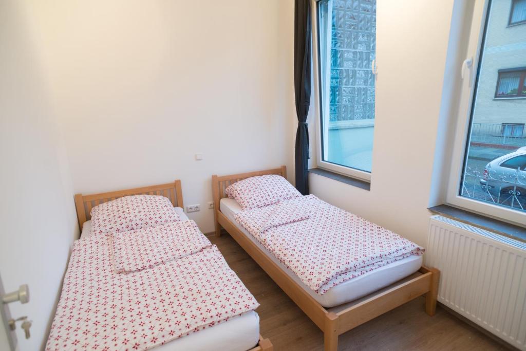 2 camas en una habitación con ventana en FeWo Engler Bremen Ritterhuder Straße, en Bremen