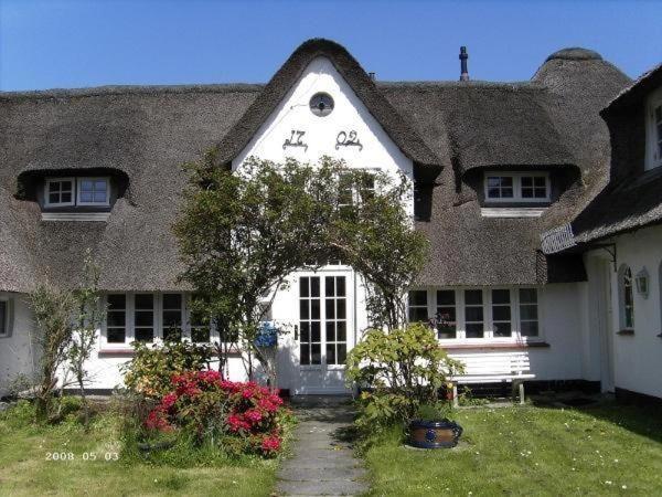 ein großes weißes Haus mit einem Strohdach in der Unterkunft Grenzhof, Elisabethwohnung in Westerland