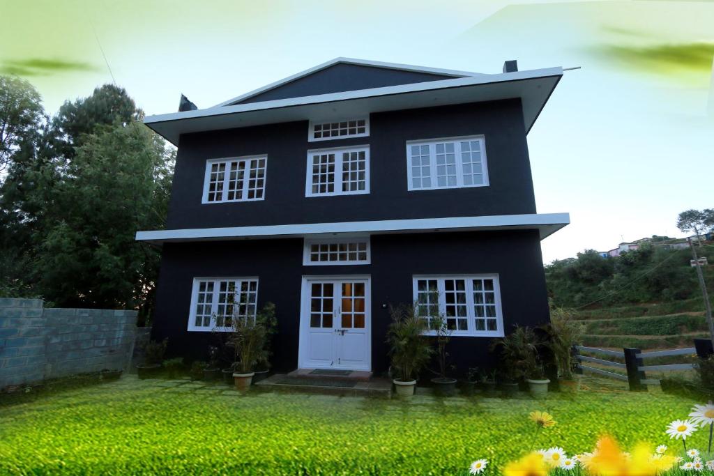 a black house with a white door at The Black Magic Cottage in Ooty