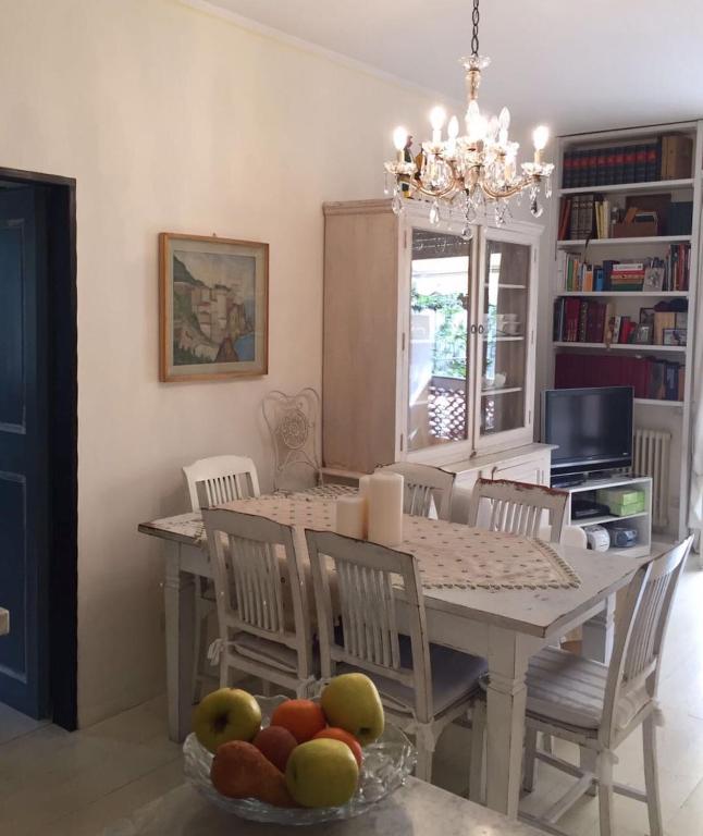 een eetkamer met een tafel en stoelen met een fruitschaal bij La casa di nonna Giò in Luni