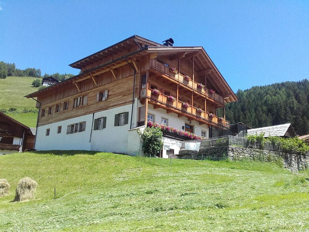a large building on top of a green hill at Gesenhof in Sesto