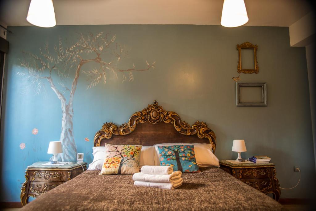 a bedroom with a bed with a tree painted on the wall at Alojamientos Sueños de Ronda in Ronda
