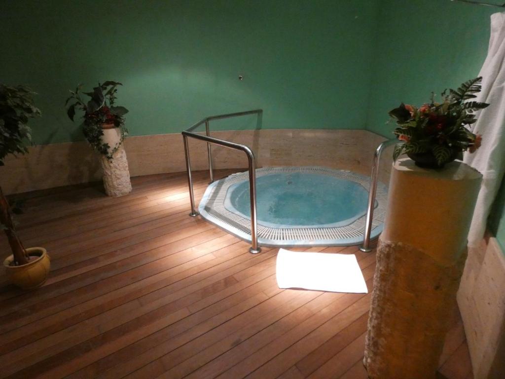 a hot tub in a room with a wooden floor at Motel Caldas in Caldas de Reis