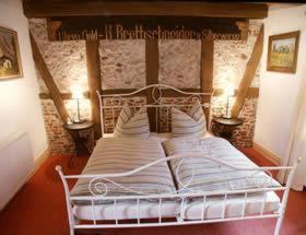 ein weißes Bett in einem Zimmer mit zwei Lampen in der Unterkunft Pension Picco-Bello in Clausthal-Zellerfeld