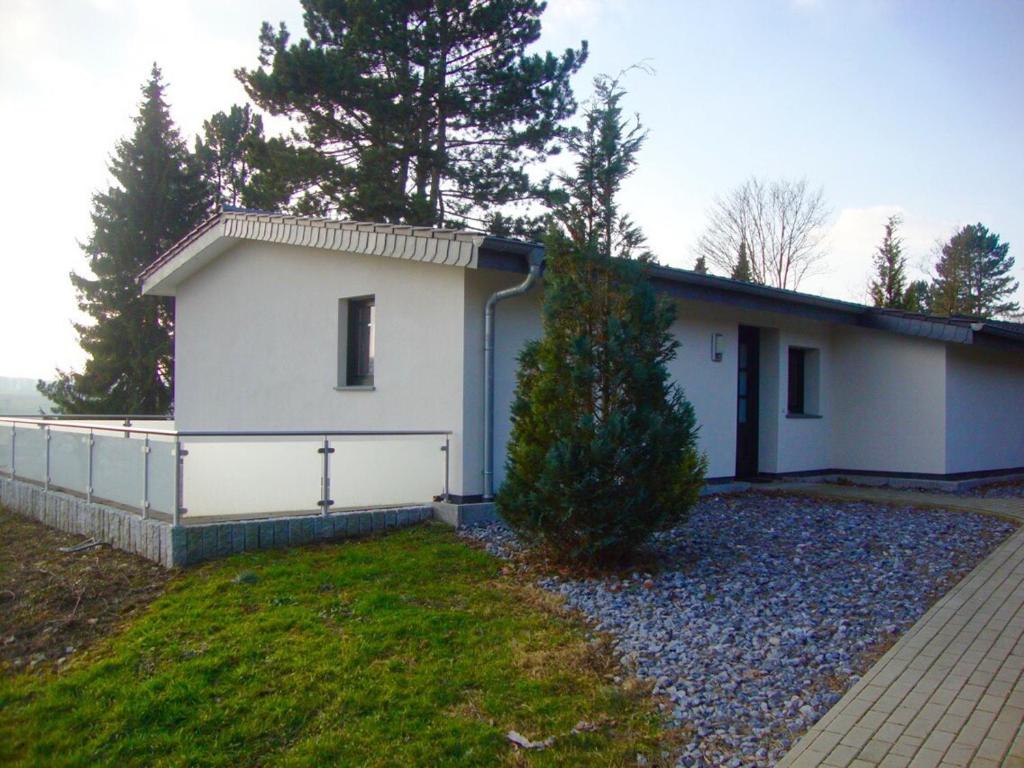 une petite maison blanche avec un arbre en face dans l'établissement Exklusives Ferienhaus keine Monteure, à Lichtenau