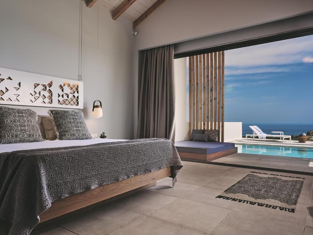 a bedroom with a bed and a view of the ocean at Hotel St.John Suites Adults Only in Tsilivi