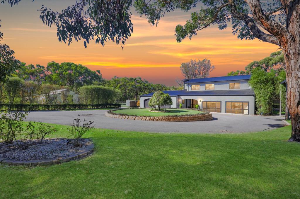 a home with a sunset in the background at Elk Estate in Inverloch