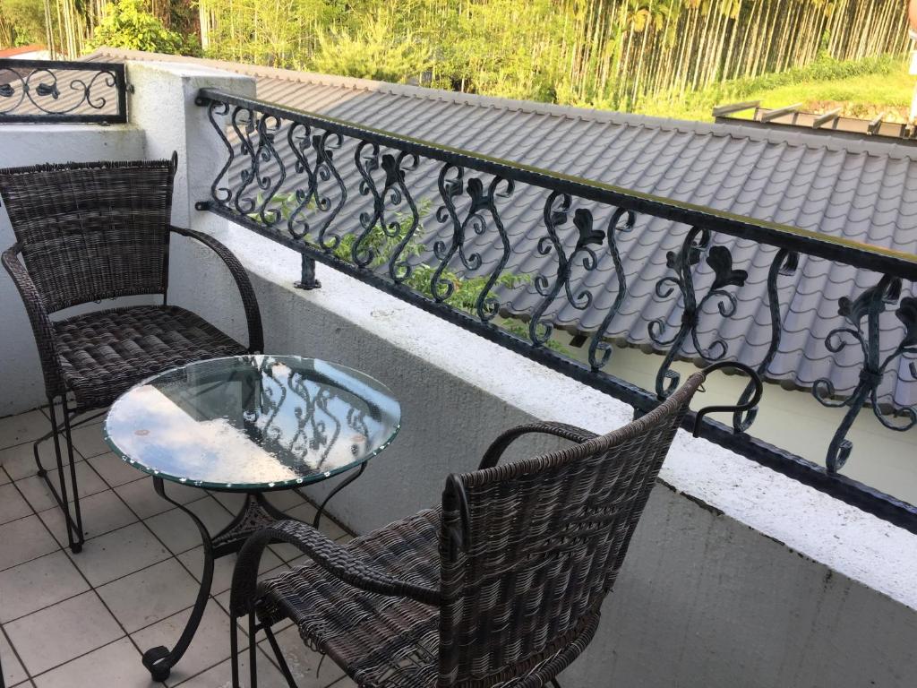 a balcony with two chairs and a glass table at 闕麒景觀民宿Chill Villa B&amp;B in Puli