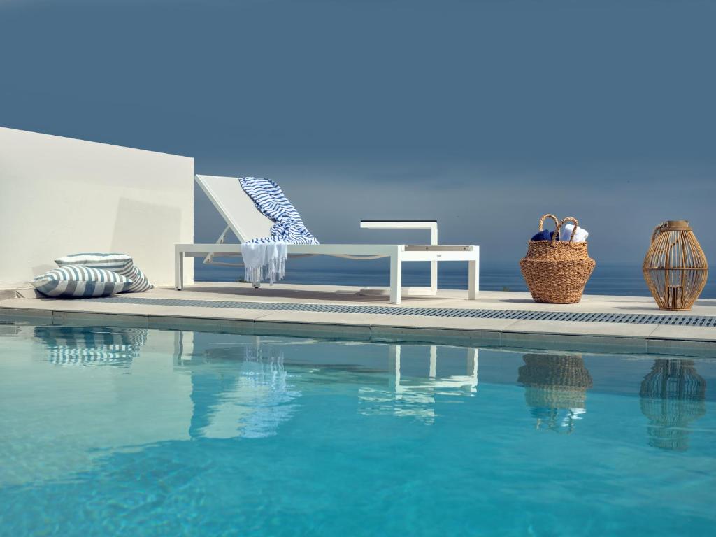 una piscina con un banco junto a una piscina en Hotel St.John Suites Adults Only, en Tsilivi