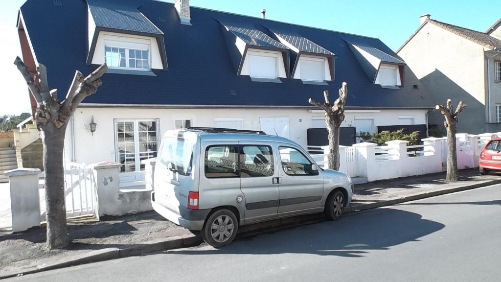 un pequeño coche aparcado frente a una casa en La Caravelle 10 Boulevard Gilbert Longuet, en Arromanches-les-Bains