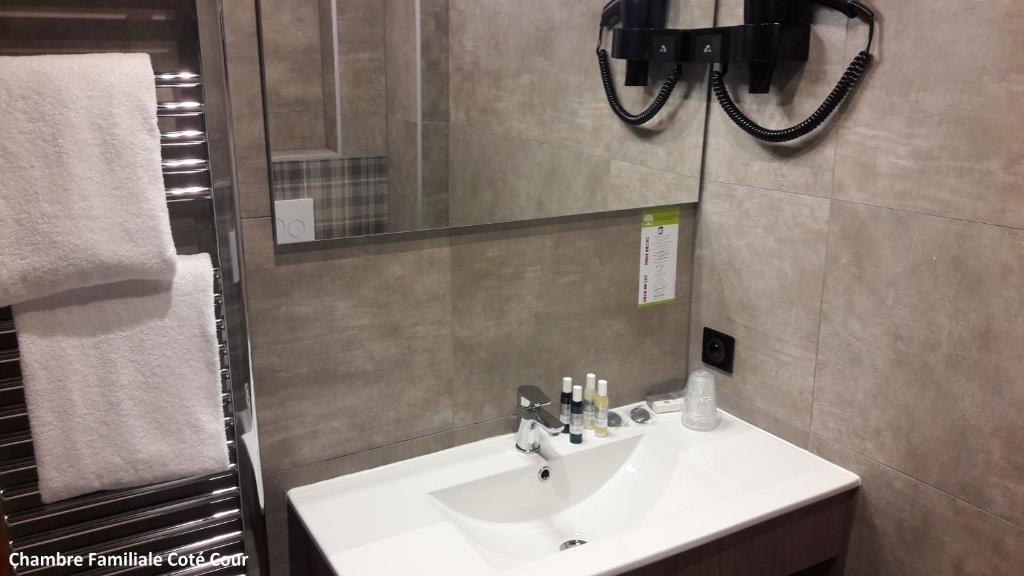 a bathroom with a white sink and a mirror at Hôtel Les Brises in La Rochelle