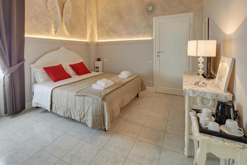 a bedroom with a bed with red pillows and a table at Leone X Guest House in Florence