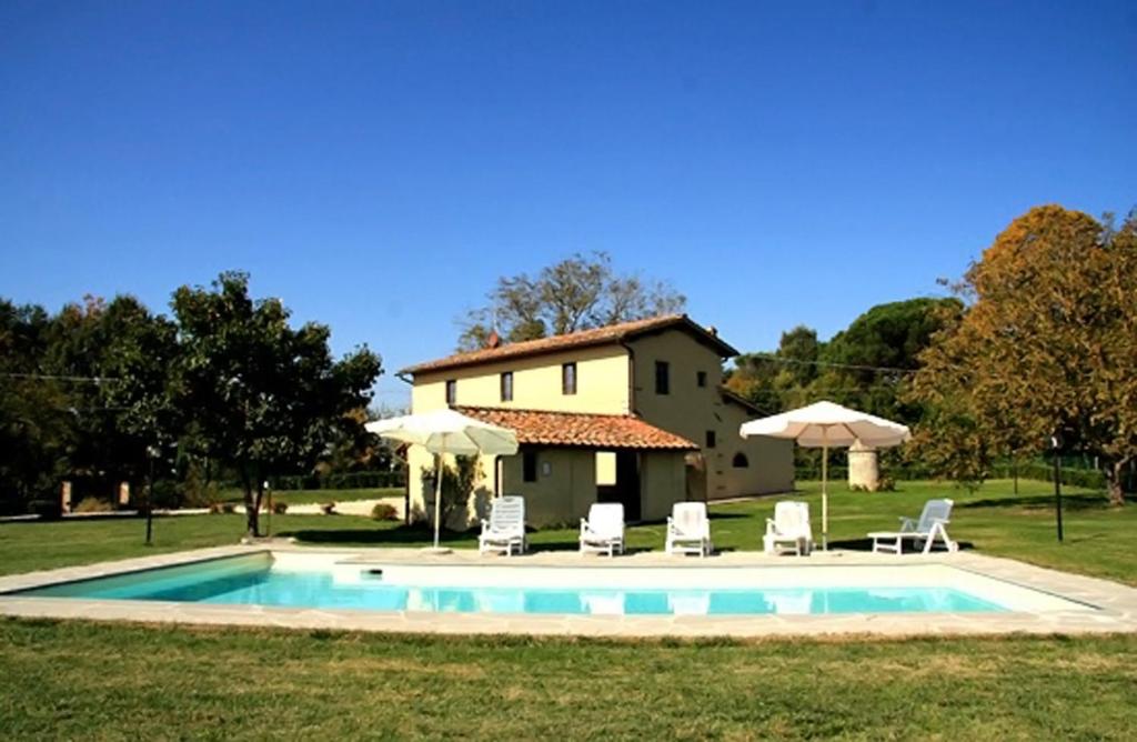 - une piscine en face d'une maison avec des chaises et des parasols dans l'établissement Tenuta Monti, à Borgo San Lorenzo