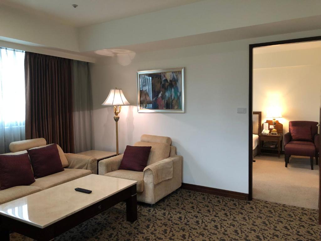 淡水區的住宿－福格大飯店，一间客厅,客厅配有沙发和一张桌子,位于酒店的房间