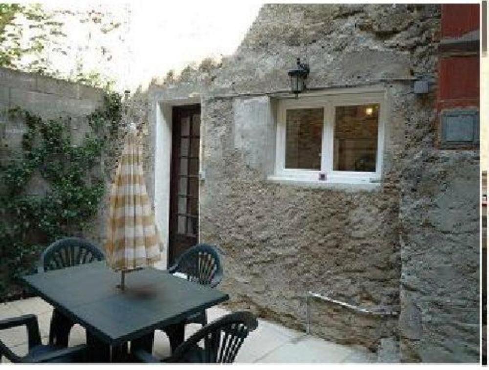 une table et des chaises devant un mur de pierre dans l'établissement Maison près Cité de Carcassonne, à Villalier
