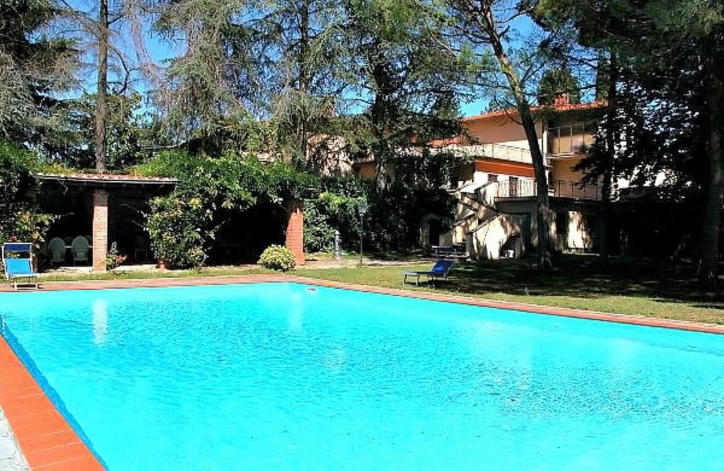 Una gran piscina azul frente a una casa en Villa Enrica, en Santa Maria a Vezzano