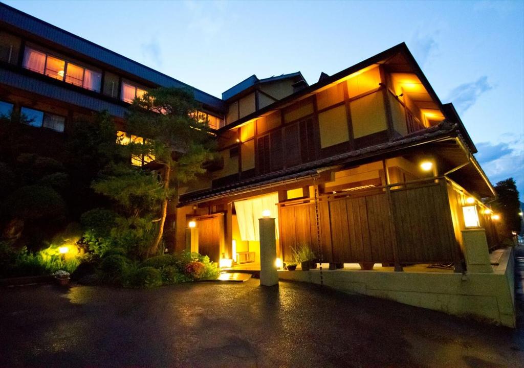 une maison avec des lumières sur son côté la nuit dans l'établissement Saikatei Jidaiya, à Kaminoyama