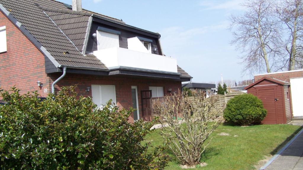 a red brick house with a white window on it at Goden Wind 20 in Westerdeichstrich