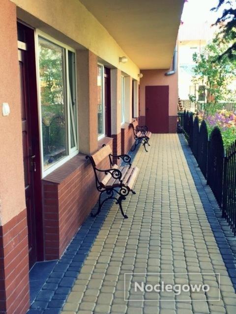 two benches sitting on a sidewalk next to a building at Obłoczek in Łeba
