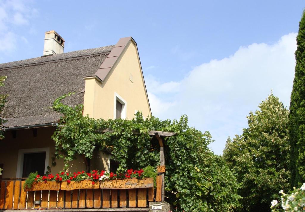 ein Haus mit Blumen im Zaun in der Unterkunft András Nádfedeles Vendégház in Tihany