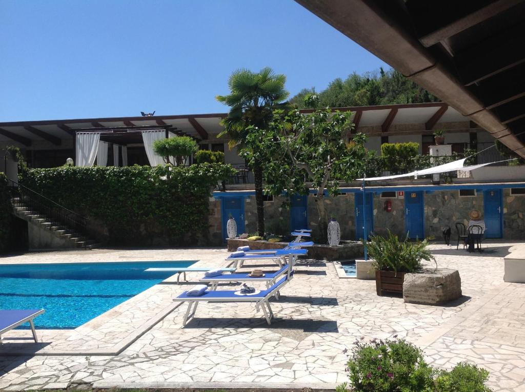 - une rangée de chaises longues à côté de la piscine dans l'établissement Hotel Boomerang Roma, à La Massimina-Casal Lumbroso