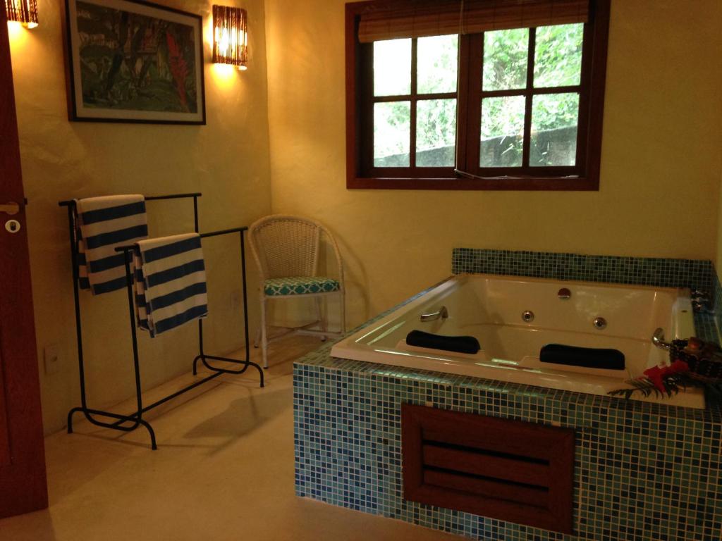 uma casa de banho com uma grande banheira num quarto em Atmosphera Pousada em Arraial d'Ajuda
