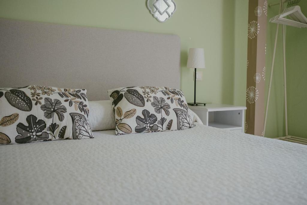 1 dormitorio con 1 cama blanca y 2 almohadas en Ronda Navarra by Valdesierra, en Béjar
