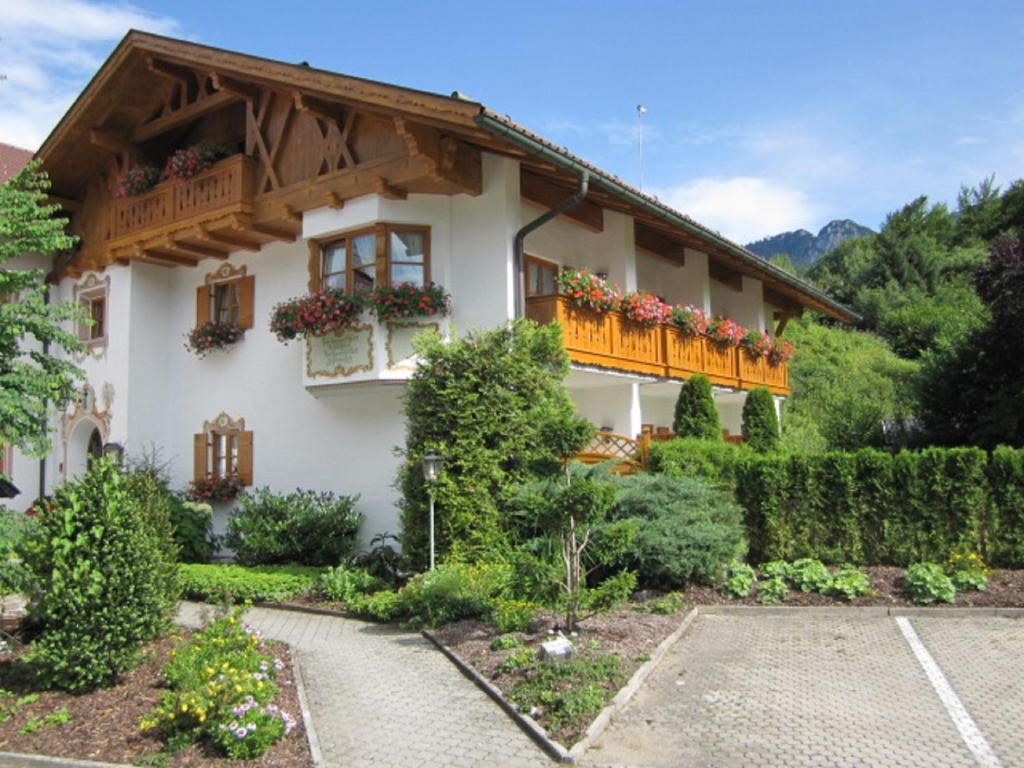 a house with a balcony with flowers on it at Hotel Alpspitz B&B in Grainau