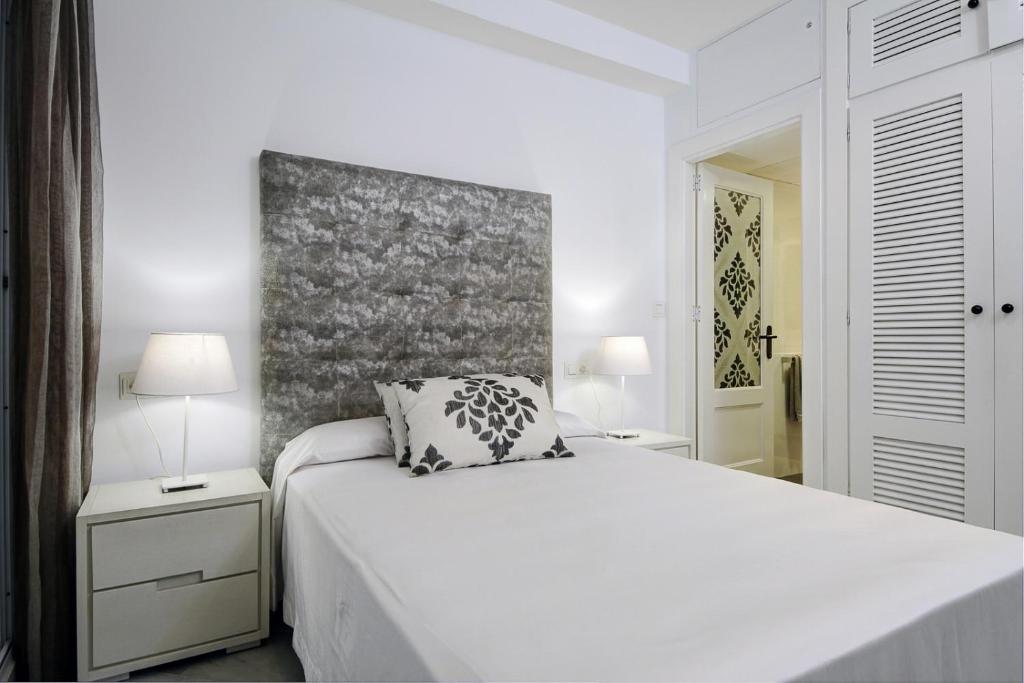 1 dormitorio blanco con 1 cama blanca y 2 lámparas en Marina Playa 2H, en La Herradura