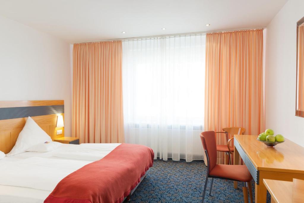 Postel nebo postele na pokoji v ubytování Ringhotel Loew's Merkur