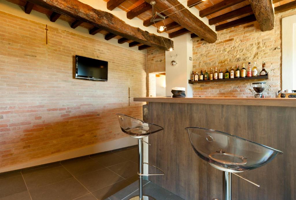 bar z dwoma krzesłami obok ściany z cegły w obiekcie Locanda Sant'Ambrogio w mieście Rivalta