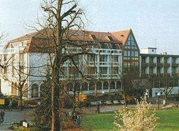 un grand bâtiment avec un arbre en face dans l'établissement Häffner Bräu, à Bad Rappenau