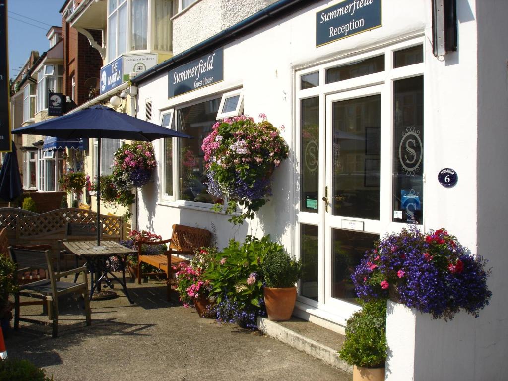 una cafetería con flores al lado de un edificio en Summerfield Guest House en Bridlington