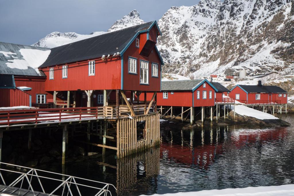 czerwony dom w doku obok góry w obiekcie Salteriet w mieście Å