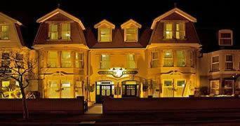 a large yellow building with a clock on it at All Seasons Lodge Hotel in Great Yarmouth