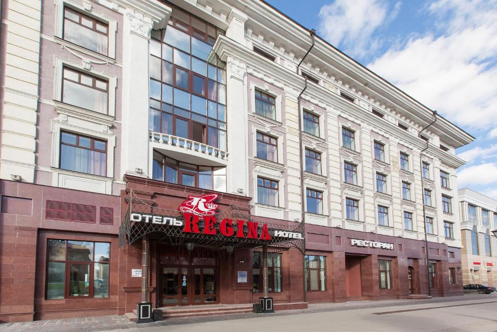 un gran edificio blanco con un cartel. en Regina na Peterburgskoy, en Kazán