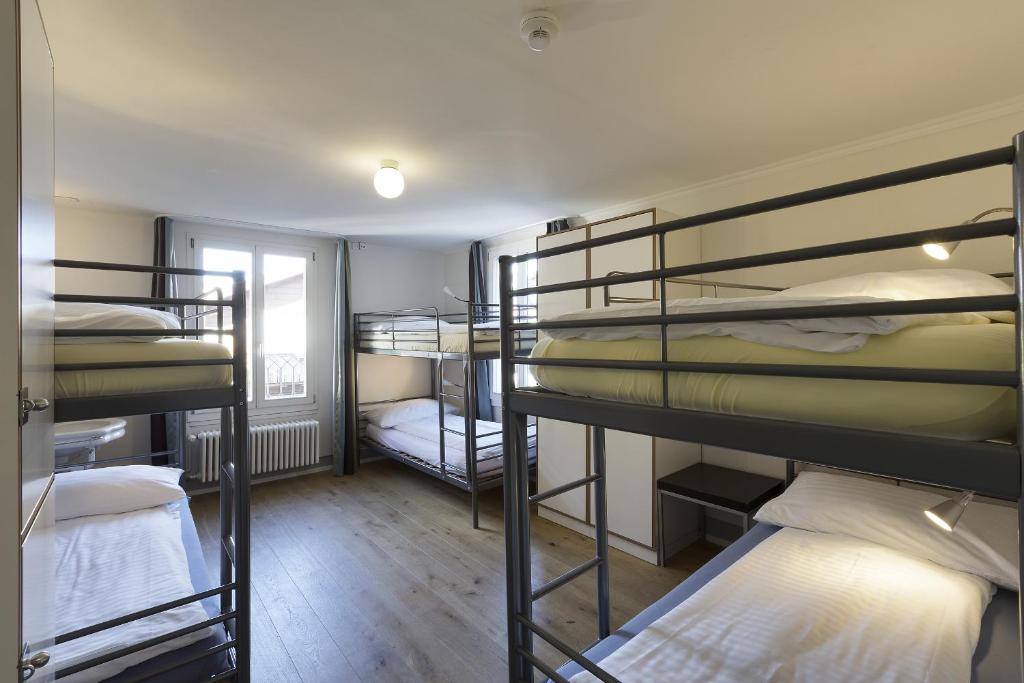 a room with several bunk beds in a building at Alplodge in Interlaken