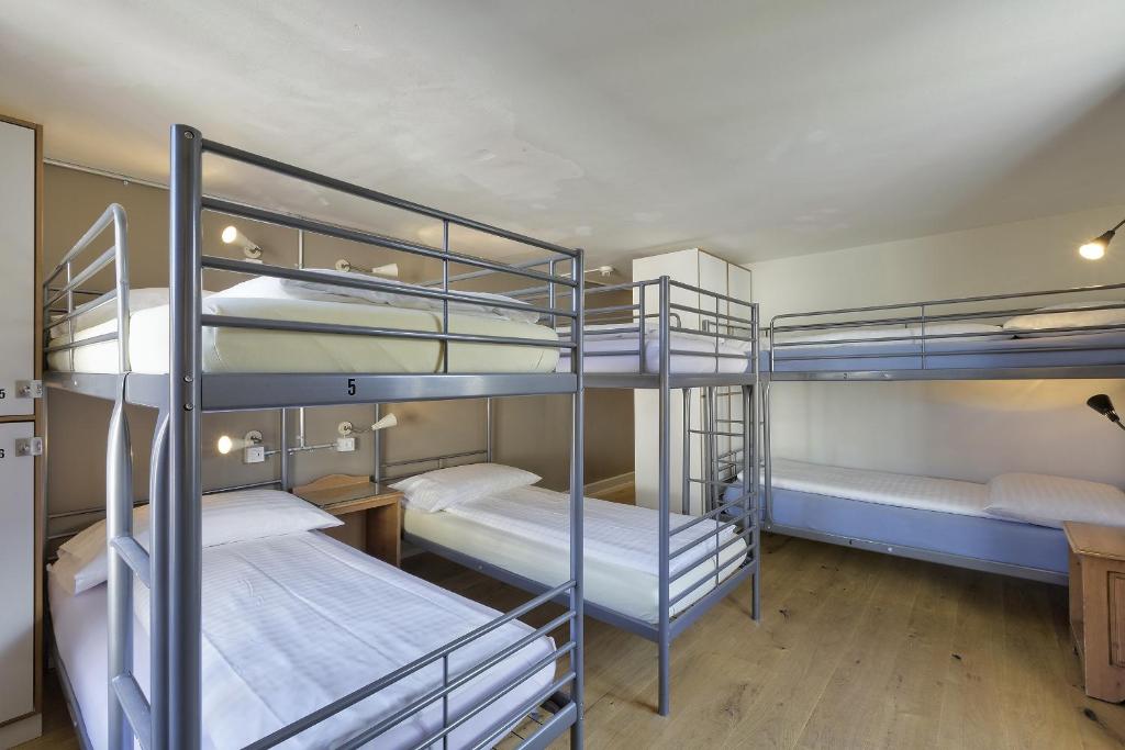 a room with three bunk beds in a building at Alplodge in Interlaken