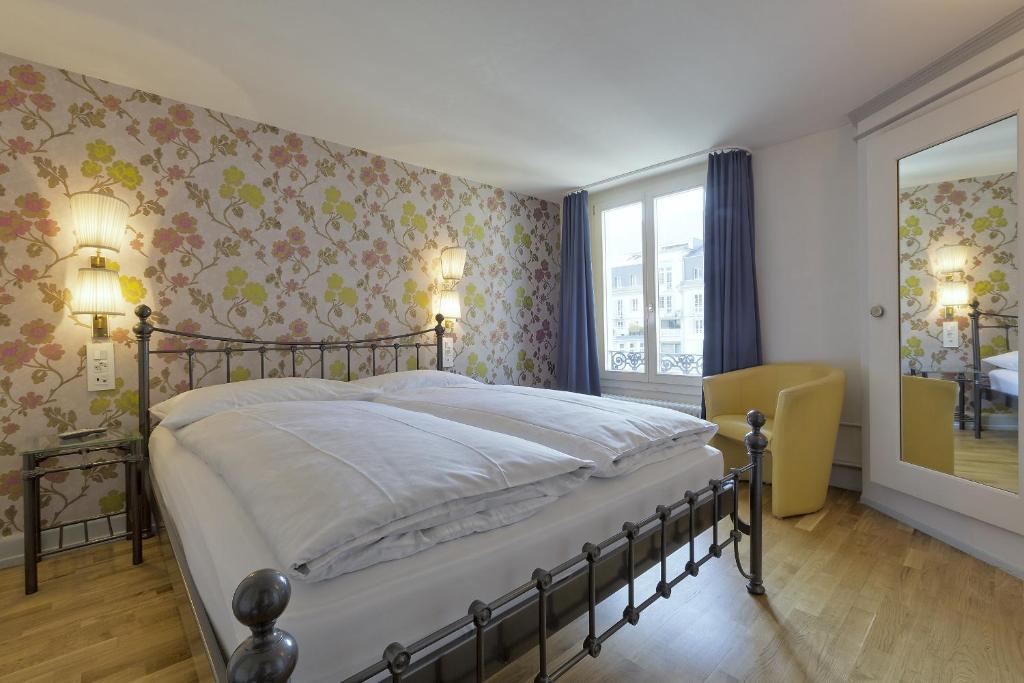 a bedroom with a large bed with floral wallpaper at Alplodge in Interlaken